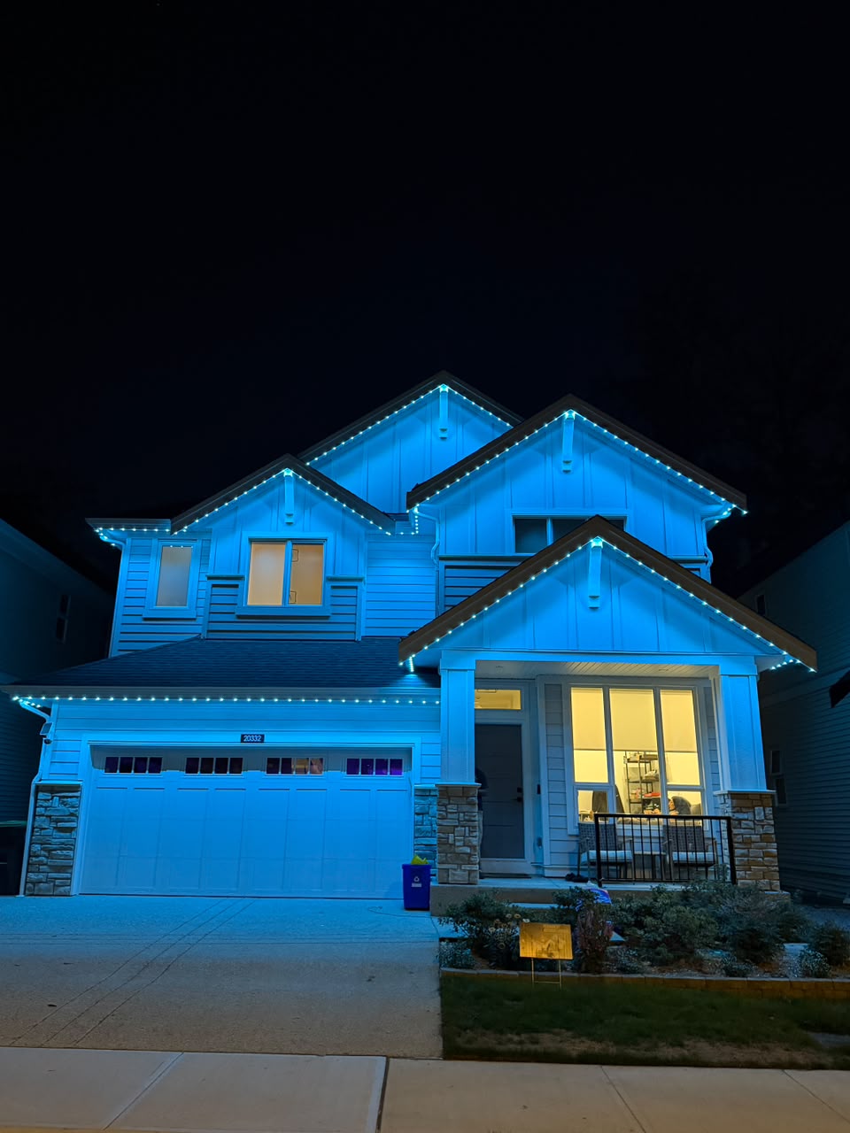 Vibrant icy blue lighting illuminating the entire roofline.