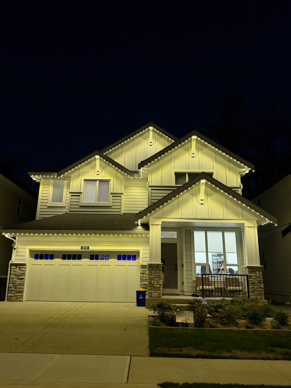 Warm white architectural lighting highlighting gables and entrance.