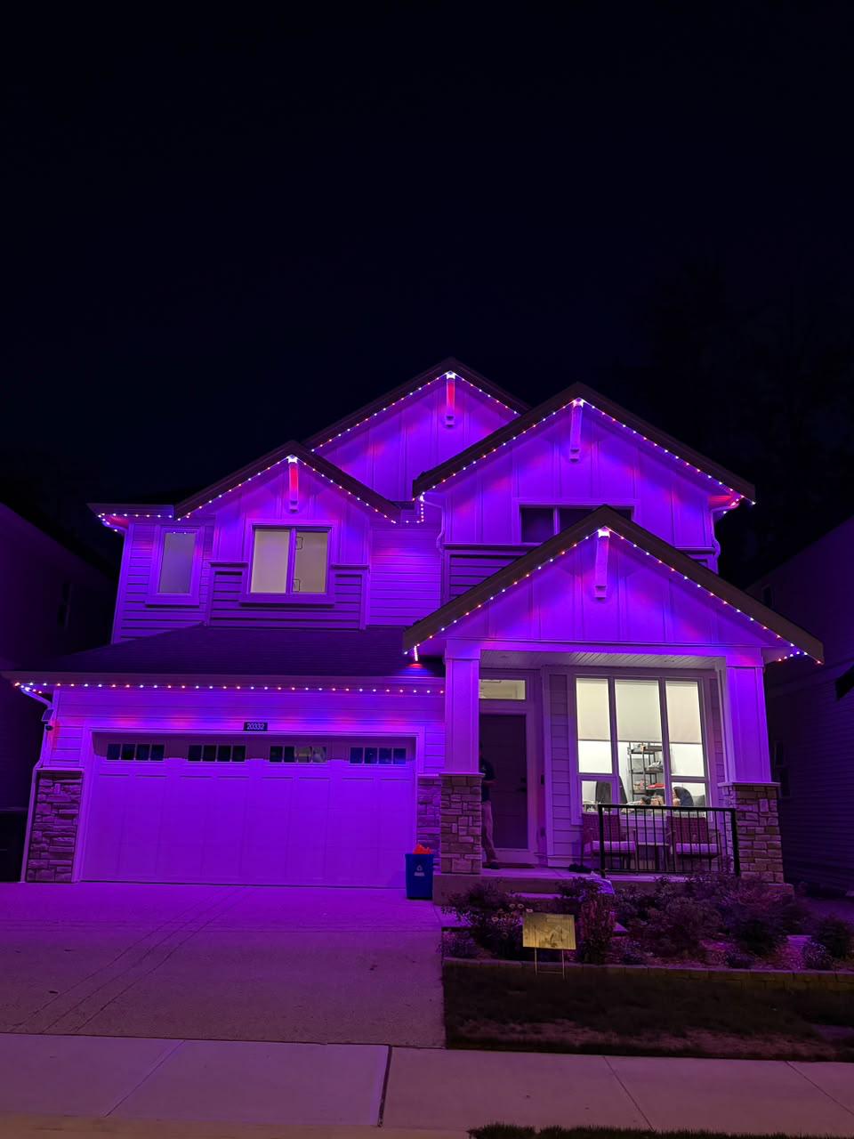 A home in Saanich lit in deep Halloween orange and purple.
